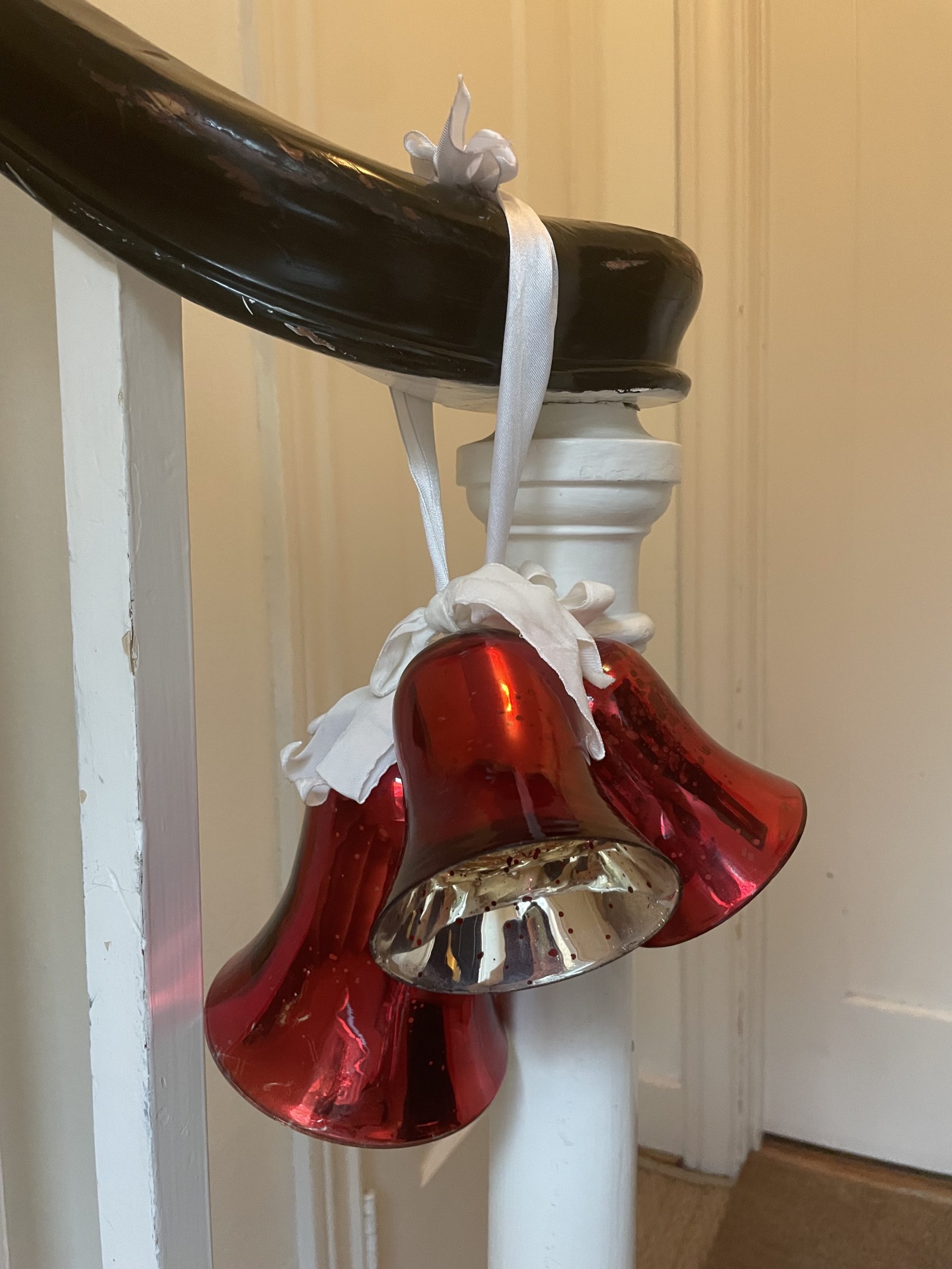 Bells from Homegoods tied with gift ribbon on staircase