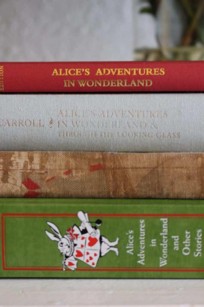 Mimi's favorite book, Alice's Adventures in Wonderland, in different prints collected over the years. 
